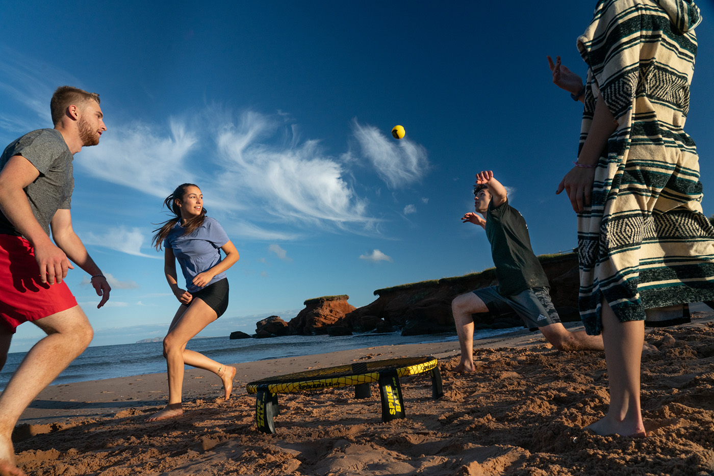 Des étudiants pratiquent le Spikeball, au bord de la plage, aux Îles-de-la-Madeleine.