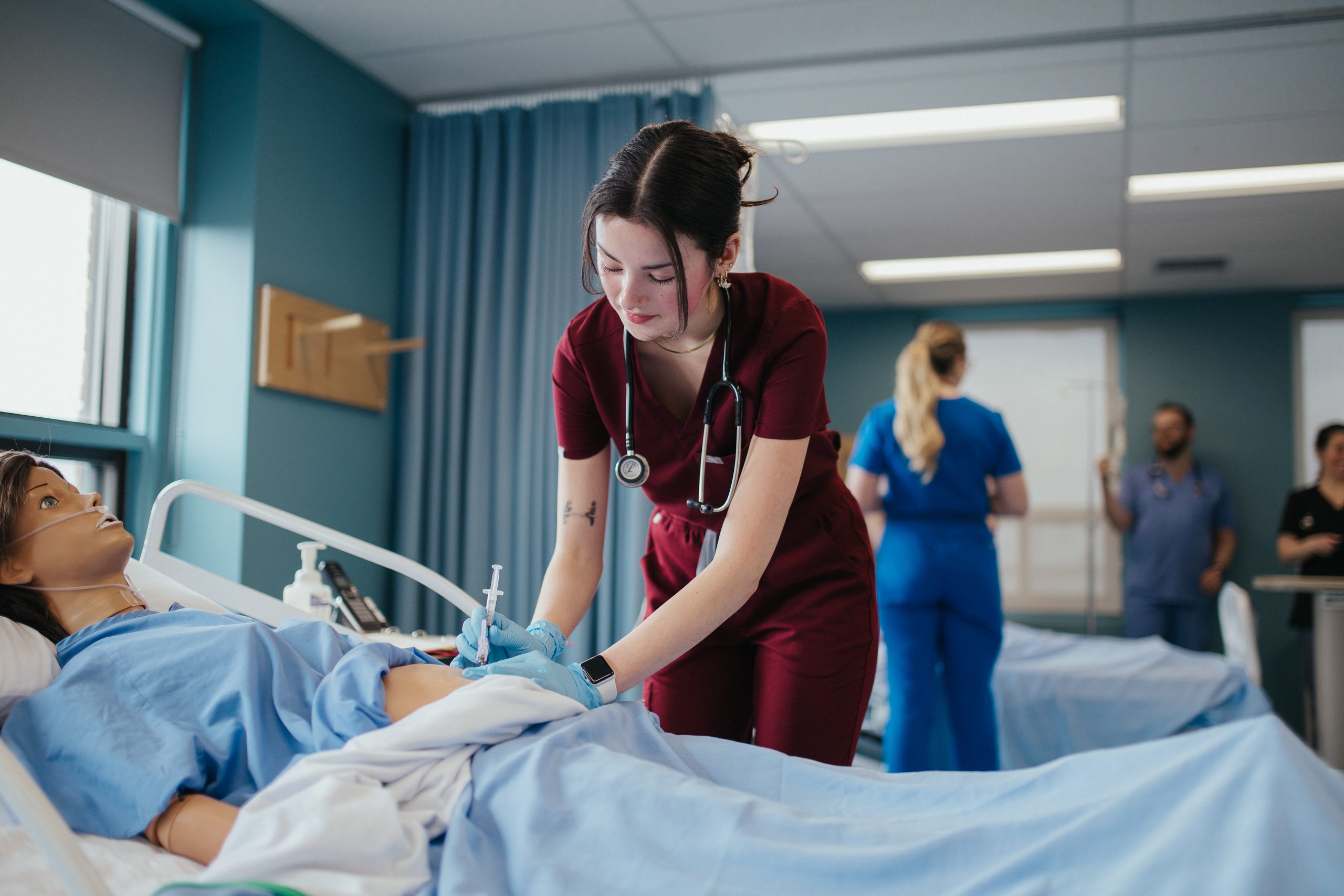 Étudiante en soins infirmier qui ausculte un patient